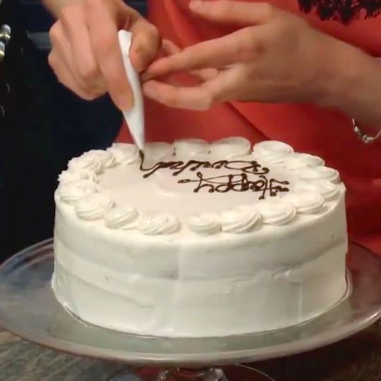 Piping words on iced cake